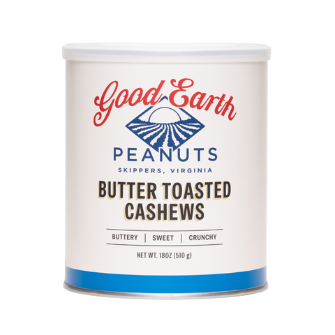 A white cylindrical canister of Good Earth Peanuts Butter Toasted Cashews, featuring a white label with red and blue branding and black text, set against a plain white background.