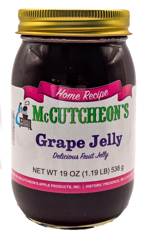 A glass jar of McCutcheon's Grape Jelly with a gold metal lid and a white label featuring green and purple text, set against a plain white background.
