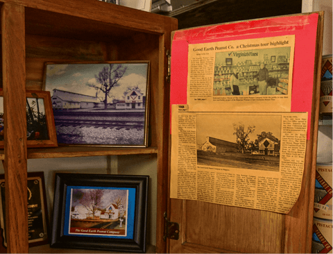 Wooden cabinet with vintage newspaper and framed pictures on a shelf