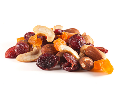 A photo on a white background of trail mix consisting of cashews, almonds and dried fruit.