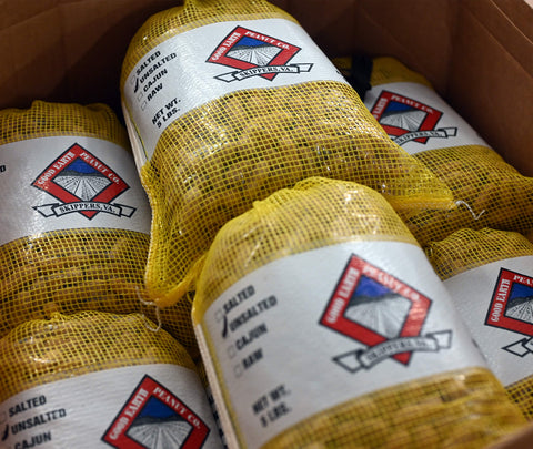 Yellow mesh bags of Good Earth Peanuts Unsalted with labels in a cardboard box